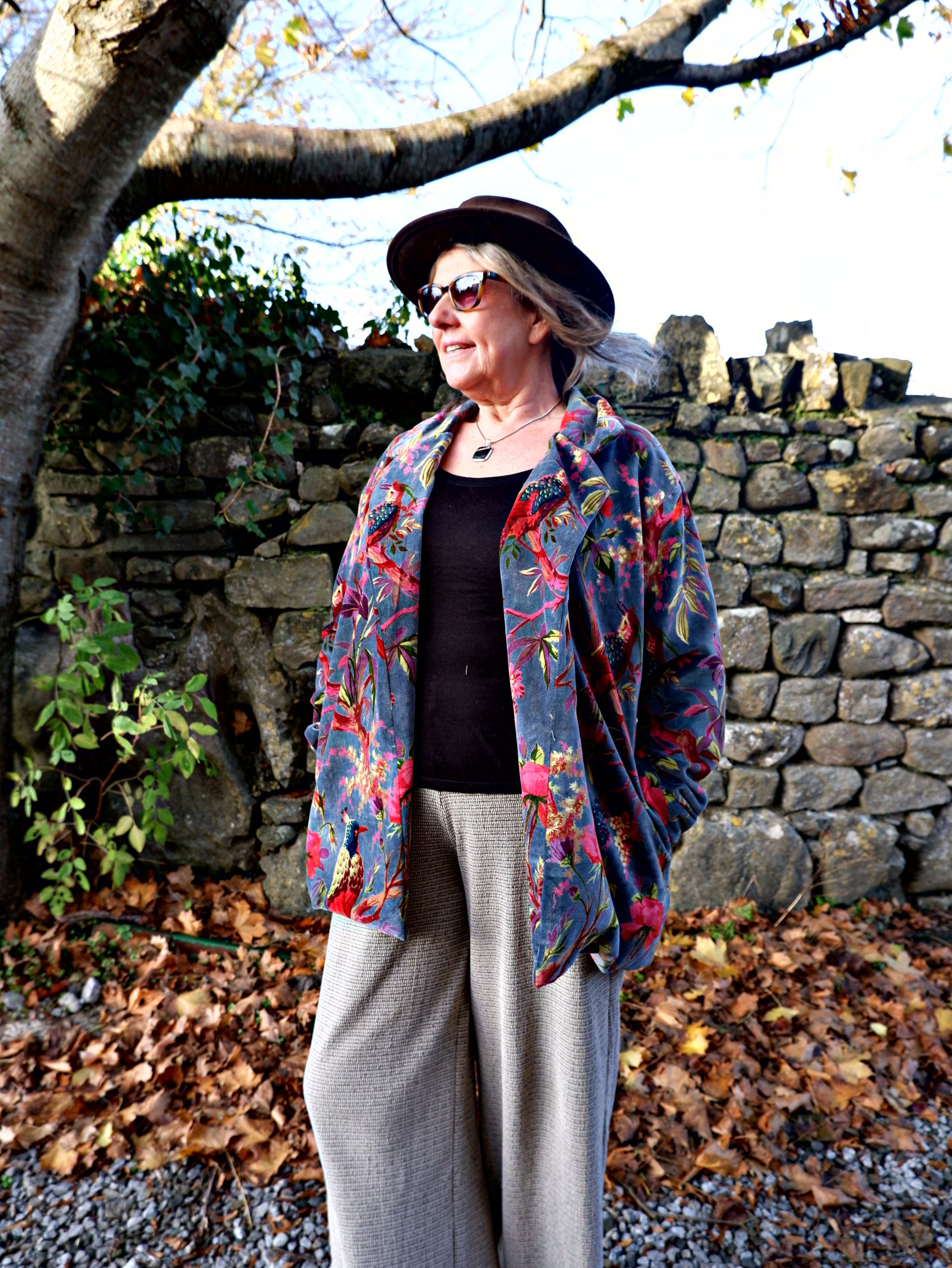 Person wearing velvet jacket in bold blue floral print