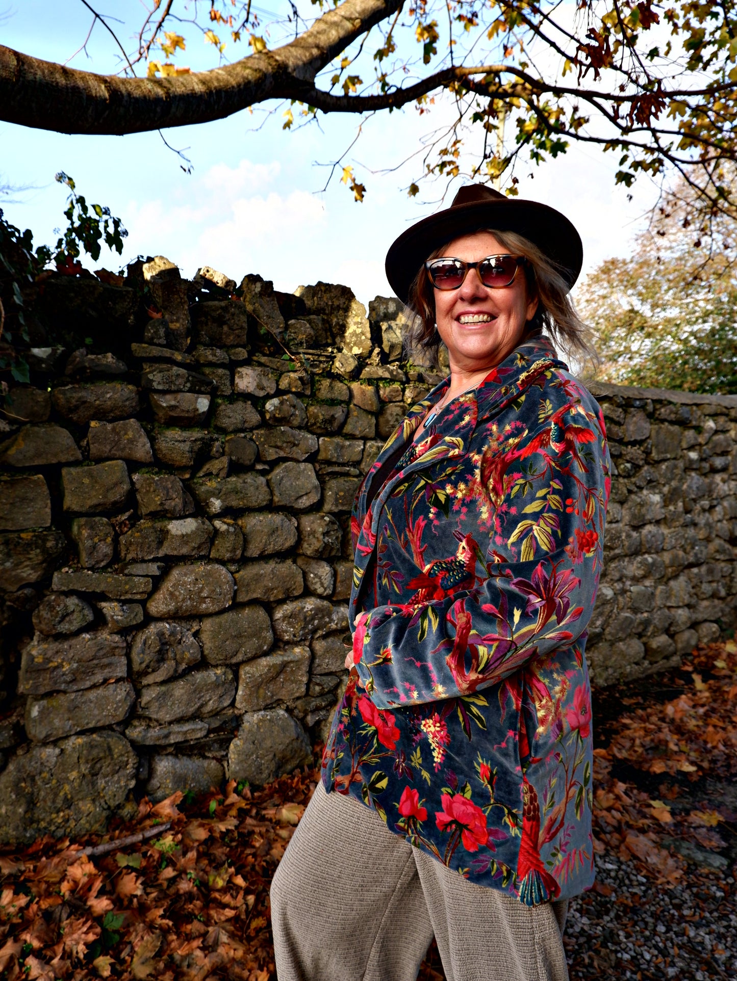 Person wearing a colorful velvet  jacket and hat 